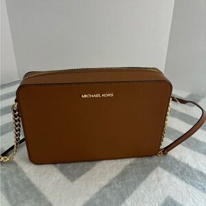 Michael Kors tan purse with gold metal accents.
